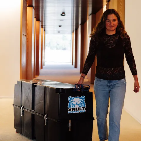 Erika Ackerlund wheeling her Vault Pro down a hotel corridor