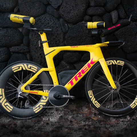 Sam Long's yellow Trek Speed Concept against a lava rock wall